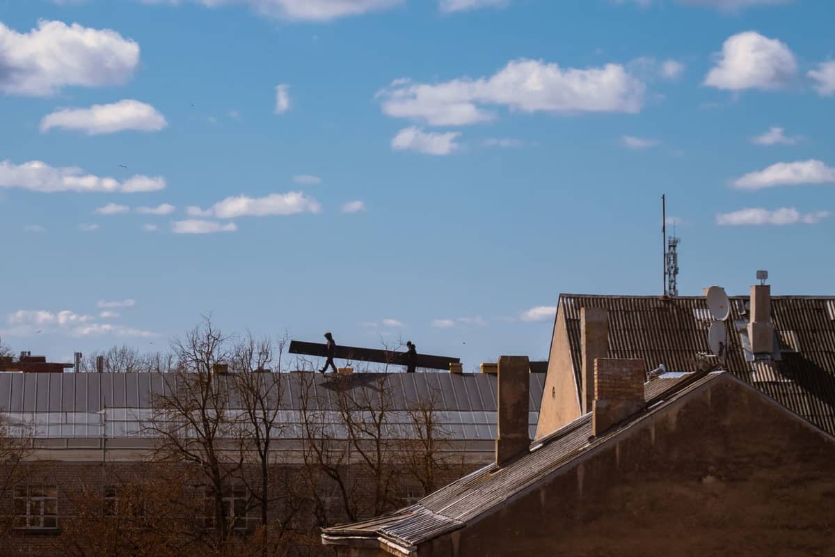 Roofing crew working on a rooftop against the sky