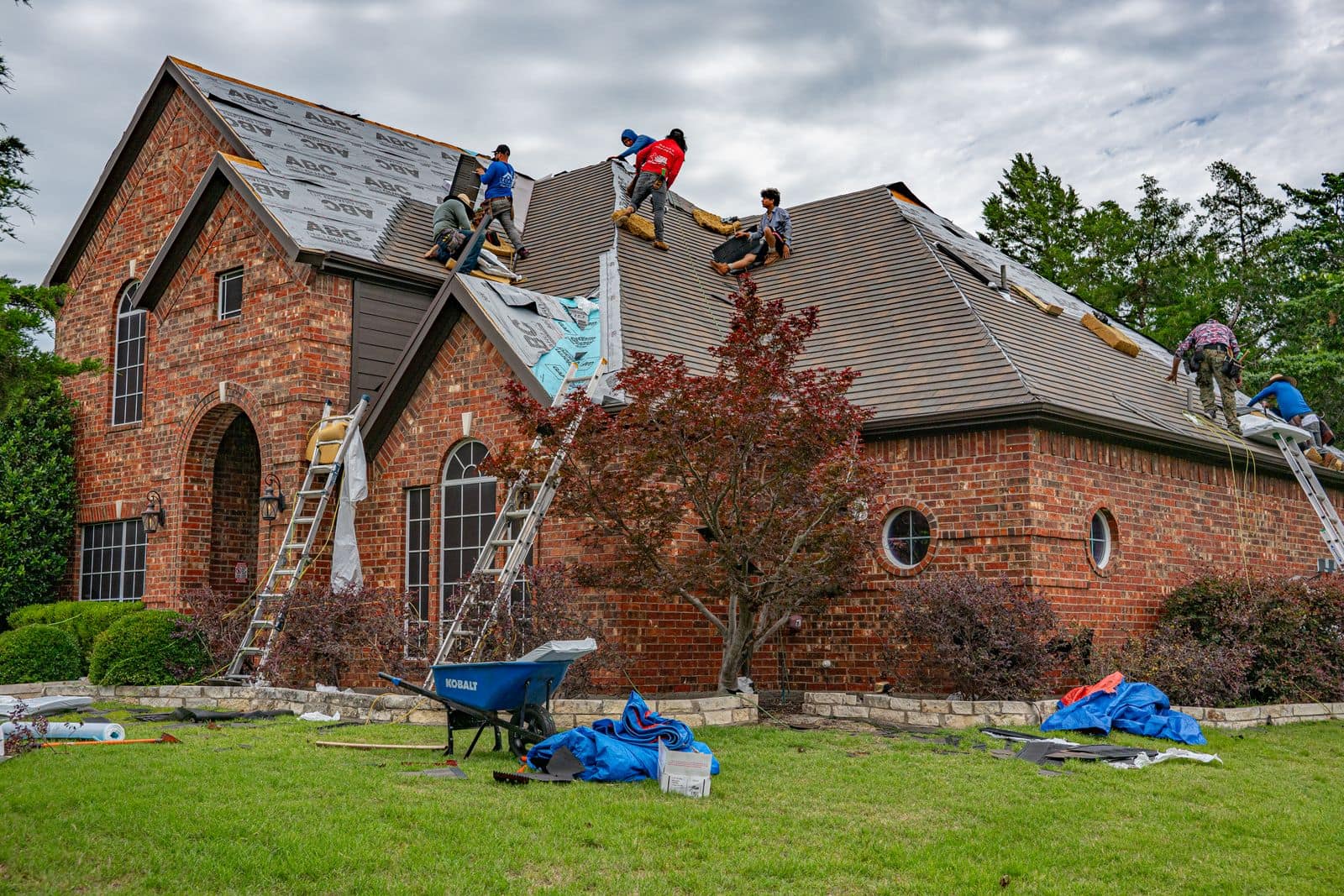 Roofers installing shingles on a house roof