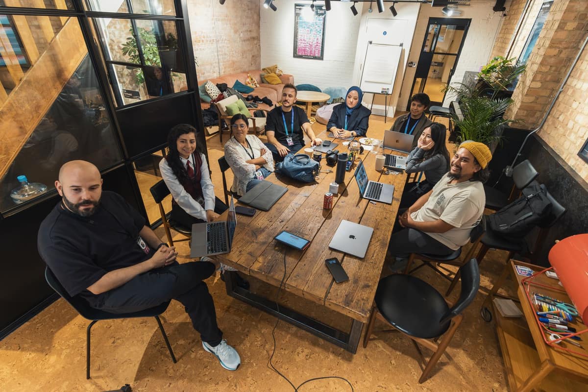 A startup team collaborating around a laptop in an open workspace